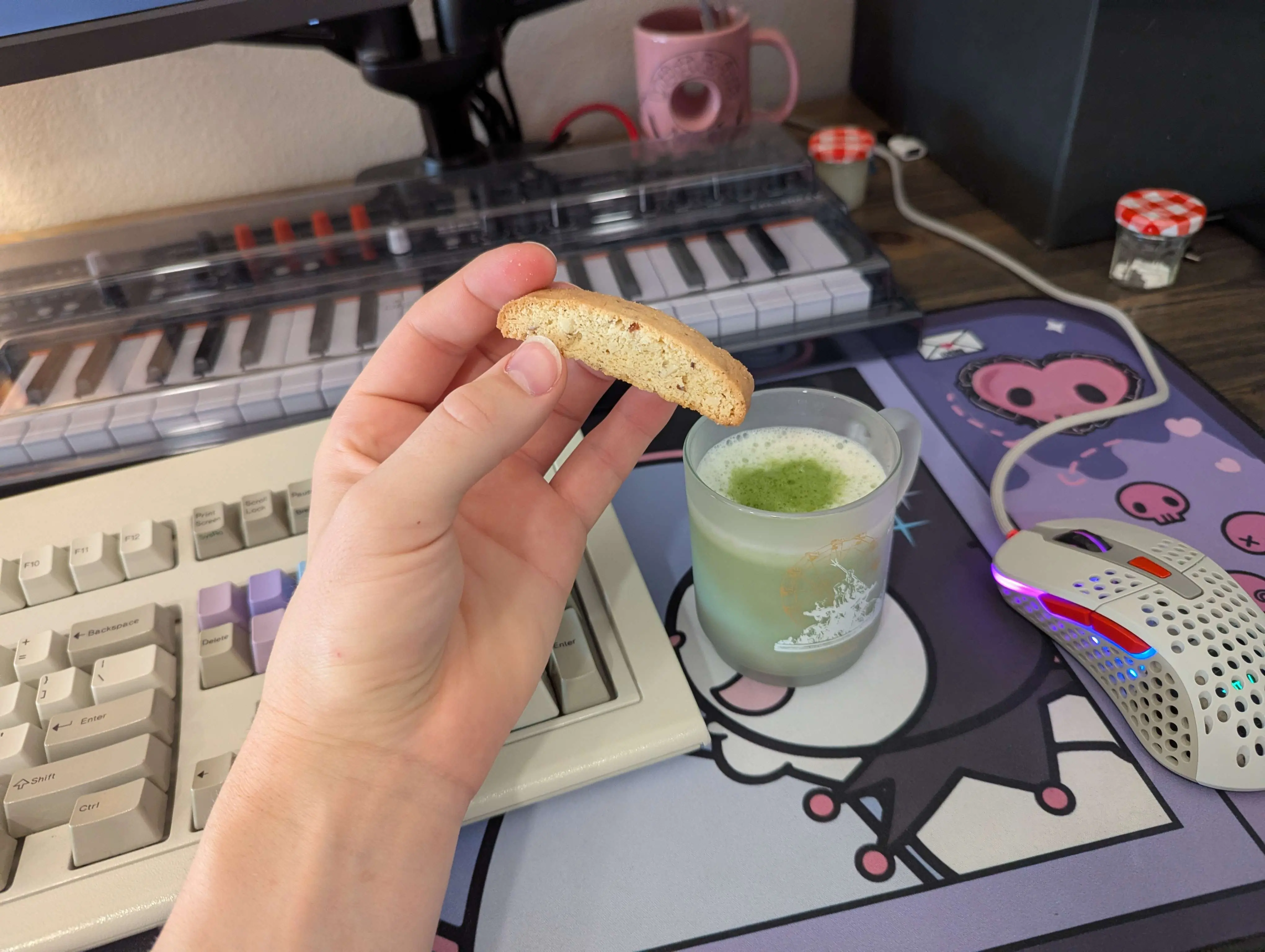 Gen's hand poised to dip her almond biscotti into a lavender matcha latte